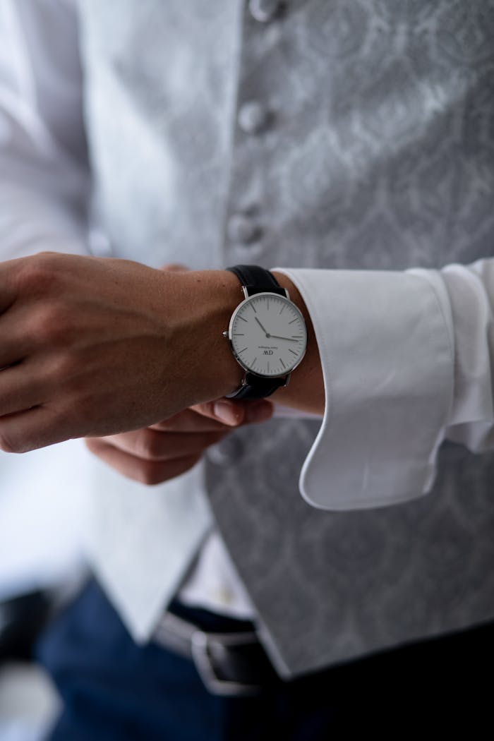 Close-up of a man adjusting his elegant wristwatch, showcasing precision and style.